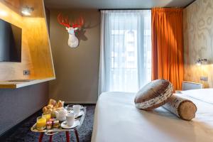 una camera d'albergo con letto e vassoio di cibo di Hôtel Le Refuge des Aiglons a Chamonix-Mont-Blanc