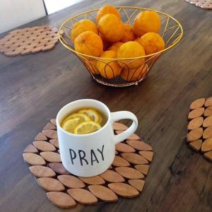 a cup of coffee on a table with a bowl of oranges at Kalahari in Sekoma