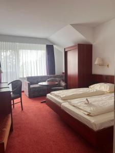 a hotel room with two beds and a couch at Hotel Seeblick garni in Gartow
