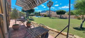 a patio with a bench and a yard with a pool at Mas Cairou in Sorède