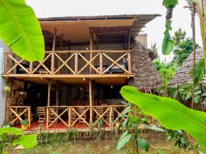 a wooden house with a porch in a forest at Arusha Jua Eco Home- on coffee farm in Arusha