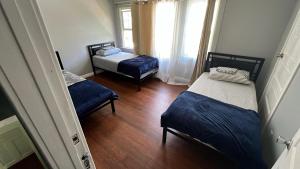a small room with two beds and a window at Journey House LA in Los Angeles