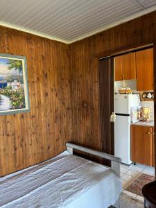 a bedroom with wooden walls and a white refrigerator at Real Holidays Antoniadou - Rustic House in Elaiokhórion