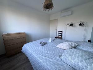 a bedroom with a bed with a dresser and a chair at Maison rénovée Montélimar in Montélimar