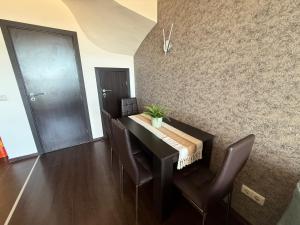 a dining room with a table and leather chairs at Sweet home see view pool escape in Nesebar