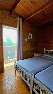 a bedroom with two beds and a large window at Ferme Sacrée Nature in Ben Slimane +35 photos