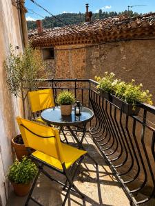 a patio with a table and chairs on a balcony at Chez Mamé Marie in Fraissé-des-Corbières