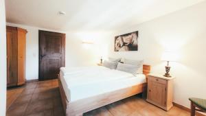 a bedroom with a large white bed and a table at Luna Mia Apartment 4 in Schwangau