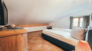 a bedroom with a bed and a desk and a television at Luna Mia Apartment 4 in Schwangau