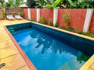a swimming pool with blue water in a backyard at Arusha Jua Eco Home- on coffee farm in Arusha