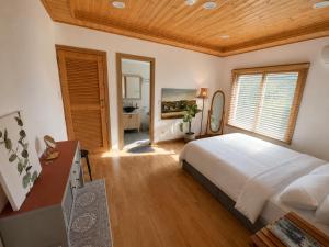 a bedroom with a large bed and a wooden ceiling at Executive Home in Jeju in Jeju