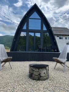two chairs and a fire pit in front of a building at Black Pepper in Yaremche