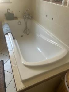 a white bath tub sitting in a bathroom at La maison bleue de Béa in Musigny