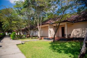 a house with a grass yard in front of it at Chamba Valley Exotic Hotel in Lusaka
