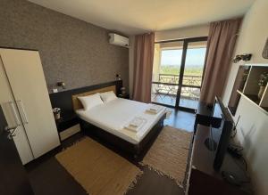 a small bedroom with a bed and a balcony at Sweet home see view pool escape in Nesebar +7 photos