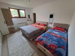 a bedroom with two beds and a television in it at AMADA apartman in Vranješ