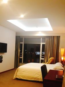 a hotel room with a bed and a large window at Khách sạn APPLAZA in Hòa Bình
