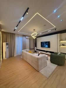 a living room with a couch and a flat screen tv at TC luxury home in Lekki