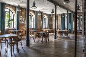 a dining room with tables and chairs and windows at Palac i Loft Ojrzanów in Ojrzanów
