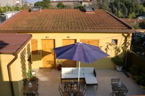 una casa y un patio con sombrilla y sillas en The Yellow House 2, en Oporto