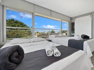 a bedroom with three beds and a large window at AC - Piscina - 1 Suite com banheiro - 200m do mar in Guarujá