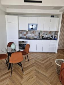 a kitchen with white cabinets and a table and chairs at Azur Pearl - Luxury Sea View Apartement - La plage à vos pieds in Nice