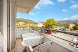 a balcony with a table and chairs and a view at Sunset Studio Apartments Bjelila in Tivat