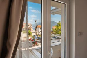 a window with a view of a city at Sunset Studio Apartments Bjelila in Tivat
