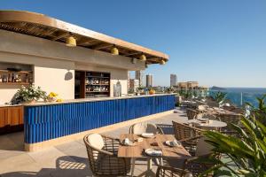 an outdoor patio with tables and chairs and a bar at Port Benidorm Hotel & Spa 4* Sup in Benidorm
