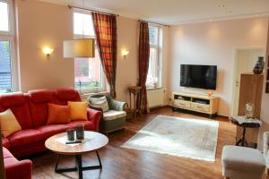 a living room with a red couch and a tv at Ferienwohnung Bubikat in Borkum