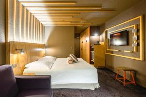 シャモニー・モンブランにあるオテル ル レフュージ デ ゼイグロンの大型ベッド1台、テレビが備わる客室です。