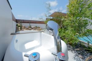 a white hairdryer sitting on the side of a house at 2026年8月新築,海直結!!ビーチフロント,オーシャンビュー,プール,サウナ付きヴィラ---Taito Pool EDGE--- in Chōjamachi