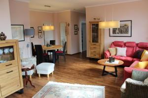 a living room with a red couch and a table at Ferienwohnung Bubikat in Borkum