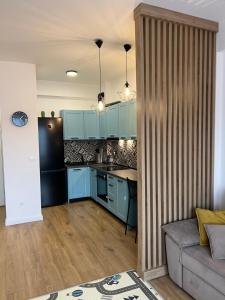 a kitchen with blue cabinets and a couch in a room at Doce Refugio in Bar