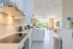 a kitchen with white appliances and a large window at Breakers Resort 130 Umhlanga Beachfront in Durban