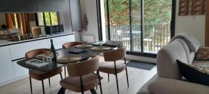 a dining room with a table and chairs and a kitchen at Le Vivastella in Cucq
