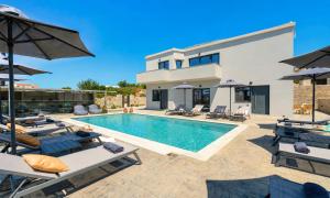 a villa with a swimming pool and patio furniture at Pranvera Villa Sea View & Pool in Dhrámia