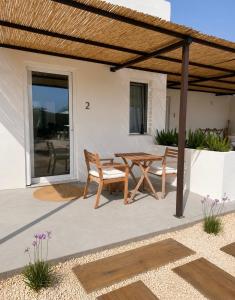 a patio with a wooden table and chairs at Ziran in Noto
