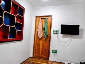 a room with a door with a television and a door with a towel at Alpine Hub Gurez in Wāmpor