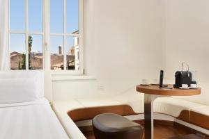 a room with a bed and a table and a window at Palazzo Montemartini Rome, A Radisson Collection Hotel in Rome