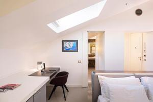 a white kitchen with a desk and a chair at Palazzo Montemartini Rome, A Radisson Collection Hotel in Rome