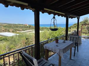 a table and chairs on a balcony with a view of the ocean at Real Holidays Antoniadou - Rustic House in Elaiokhórion