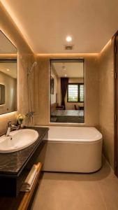 a bathroom with a tub and a sink and a mirror at A30 Hotel & Apartment in Lưu Xá +46 photos