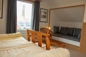 a bedroom with a bed and a window with a couch at Ferienwohnung Bubikat in Borkum