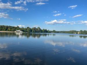 a large body of water with trees in the background at La maison bleue de Béa in Musigny