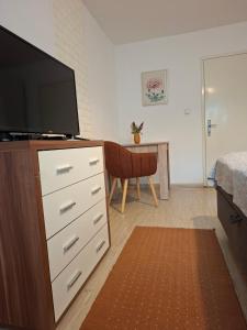 a living room with a dresser with a tv on it at Guest House Olbina in Korenica