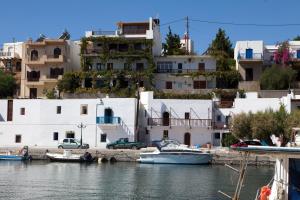 a group of white buildings and boats in the water at Porto Beach Apartment in Makry Gialos