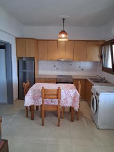 a kitchen with a table and chairs and a dishwasher at Porto Beach Apartment in Makry Gialos