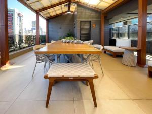 a table and chairs in a room with a balcony at Way Bossa in João Pessoa