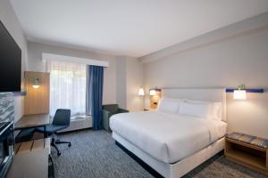 a hotel room with a white bed and a desk at Garner Hotel Sumter Northwest in Sumter +56 photos